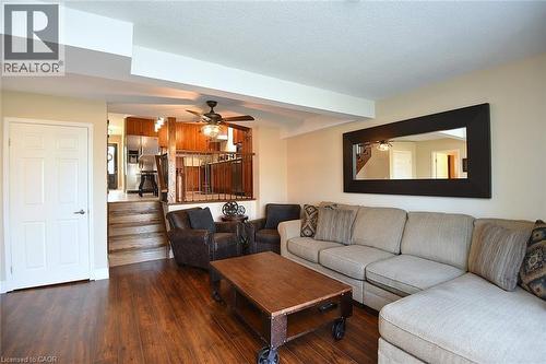 Living room with dark wood-type flooring, a ceiling fan, and a textured ceiling - 2206 Donald Road, Burlington, ON - Indoor Photo Showing Living Room