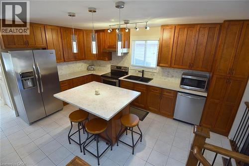 Kitchen featuring wood finish cabinets, stainless steel appliances, a center island, and hanging light fixtures - 2206 Donald Road, Burlington, ON - Indoor Photo Showing Kitchen With Double Sink