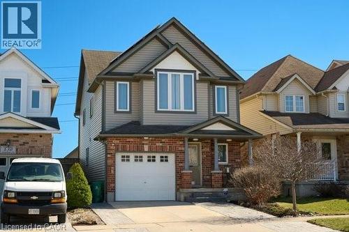 View of front of property with covered porch, a garage, concrete driveway, and brick siding - 126 Snowdrop Crescent, Kitchener, ON - Outdoor With Facade