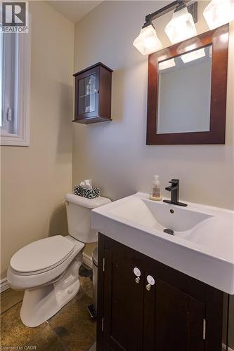 Half bathroom with vanity and dark stone finish floors - 126 Snowdrop Crescent, Kitchener, ON - Indoor Photo Showing Bathroom