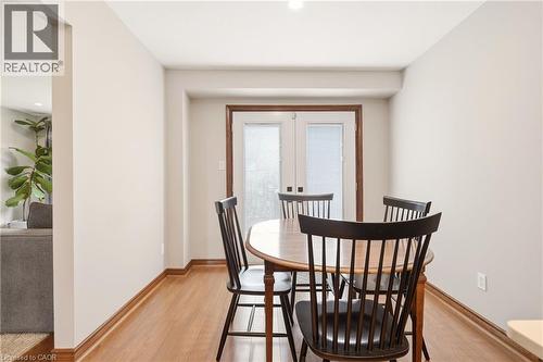 This room features light-colored walls, wood flooring, and a set of white french doors with blinds - 1 Tomahawk Drive, Grimsby, ON - Indoor Photo Showing Dining Room