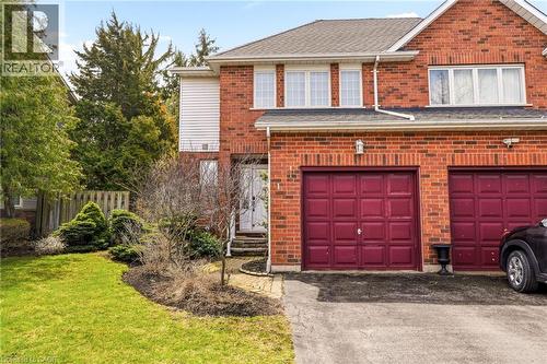 The property features a brick exterior, a driveway, and two garage doors - 1 Tomahawk Drive, Grimsby, ON - Outdoor