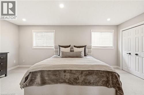 The property features recessed lighting, two windows with blinds, and light-colored carpeting - 1 Tomahawk Drive, Grimsby, ON - Indoor Photo Showing Bedroom