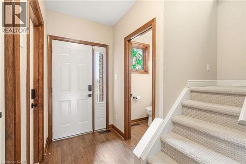 Inviting entryway featuring hardwood flooring, a white paneled door with a sidelight, and a carpeted staircase - 1 Tomahawk Drive, Grimsby, ON - Indoor Photo Showing Other Room