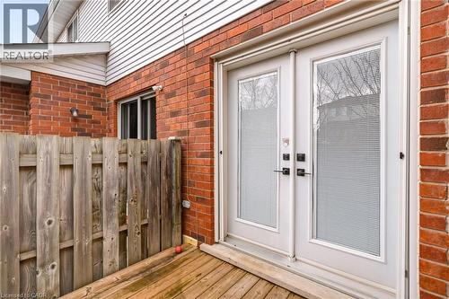 The property features a brick exterior with white siding, a wooden fence, and a wooden deck - 1 Tomahawk Drive, Grimsby, ON - Outdoor With Deck Patio Veranda With Exterior