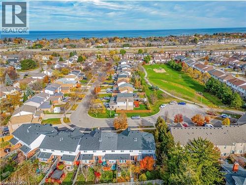 Aerial view showcasing the residential neighbourhood with a green space, mature trees, and glimpses of the water - 1 Tomahawk Drive, Grimsby, ON - Outdoor With Body Of Water With View
