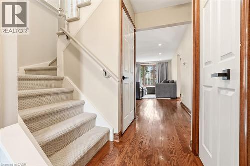 The property features a staircase with light-colored carpeted treads and a white banister, alongside rich hardwood flooring in the hallway - 1 Tomahawk Drive, Grimsby, ON - Indoor Photo Showing Other Room