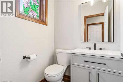 This restroom features a light gray vanity with a white countertop and a contemporary black faucet - 1 Tomahawk Drive, Grimsby, ON - Indoor Photo Showing Bathroom