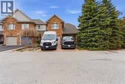 View of front of property with brick siding, driveway, and a shingled roof - 