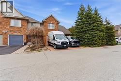View of front of property featuring brick siding, driveway, and an attached garage - 