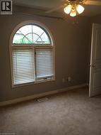 Unfurnished room with a ceiling fan and light colored carpet - 