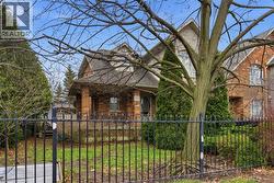View of front of house featuring a shingled roof, a fenced front yard, and brick siding - 