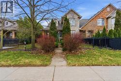 View of front of home with a fenced front yard, brick siding, and a gate - 