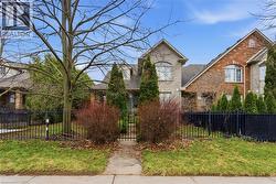 View of front facade featuring a fenced front yard, brick siding, and a gate - 