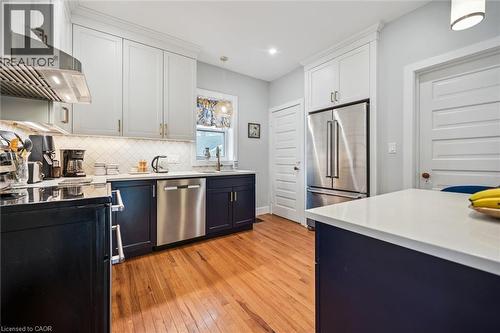Well-appointed kitchen featuring hardwood floors, stainless steel appliances, two-tone cabinetry, with a light-colored countertop - 155 Lancaster Street E, Kitchener, ON - Indoor Photo Showing Kitchen With Upgraded Kitchen