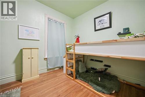 This room features hardwood floors, light green walls, and a window with a light-colored curtain - 155 Lancaster Street E, Kitchener, ON - Indoor