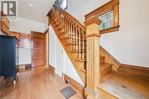 The property features a staircase with wooden steps, balusters, and a newel post, complemented by wood flooring - 155 Lancaster Street E, Kitchener, ON - Indoor Photo Showing Other Room