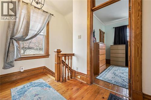 Interior hallway featuring hardwood flooring, a window with natural light, and ornate wooden banister - 155 Lancaster Street E, Kitchener, ON - Indoor Photo Showing Other Room