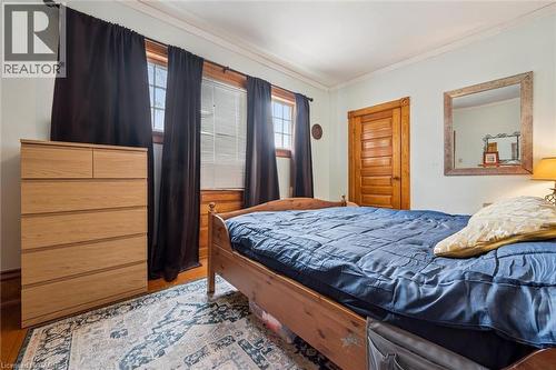 The room features hardwood flooring, wooden window frames, and a wooden door - 155 Lancaster Street E, Kitchener, ON - Indoor Photo Showing Bedroom