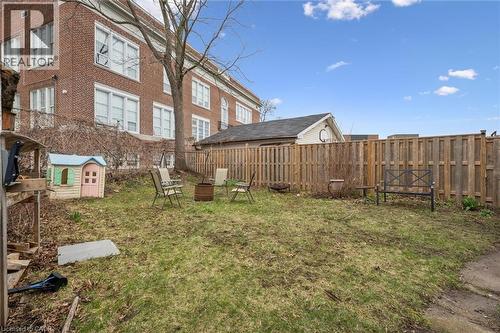 The property features a fenced yard with a lawn, a brick exterior. - 155 Lancaster Street E, Kitchener, ON - Outdoor
