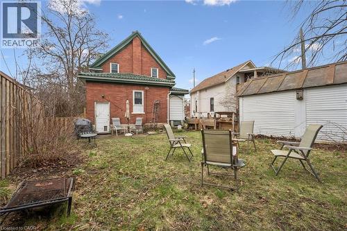 The property features a brick exterior with a green roof, a rear patio area, and a grassy yard - 155 Lancaster Street E, Kitchener, ON - Outdoor