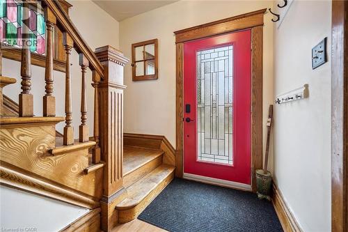 Entryway featuring a red door with decorative glass, wood trim, and a staircase with a wood banister and stained glass window details - 155 Lancaster Street E, Kitchener, ON - Indoor Photo Showing Other Room