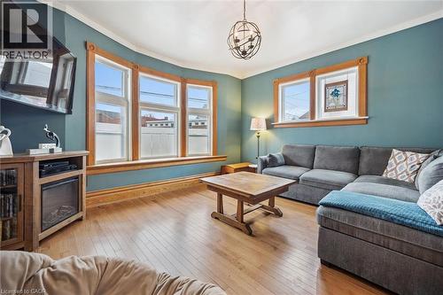 Living area featuring hardwood floors, a bay window with wood trim, and a decorative light fixture - 155 Lancaster Street E, Kitchener, ON - Indoor Photo Showing Living Room