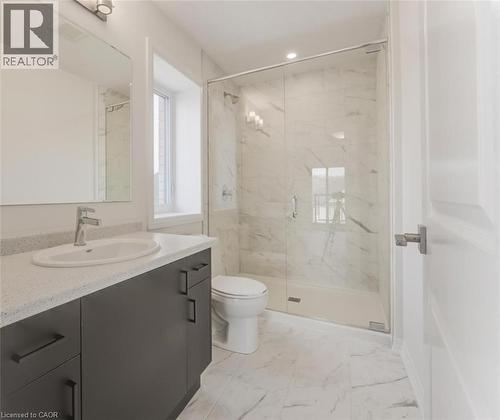 Well-appointed bathroom featuring a modern vanity with a light-colored countertop, a spacious walk-in shower with glass enclosure, and elegant marble-effect floor and wall tiling - 686 Benninger Drive, Kitchener, ON - Indoor Photo Showing Bathroom