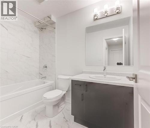 Bathroom featuring a white bathtub, a toilet, and a vanity with a white countertop and a dark base - 686 Benninger Drive, Kitchener, ON - Indoor Photo Showing Bathroom