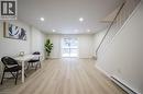 The property features light-toned flooring, a staircase with white railings, and a sliding glass door providing natural light - 212 Westcourt Place, Waterloo, ON  - Indoor Photo Showing Other Room 