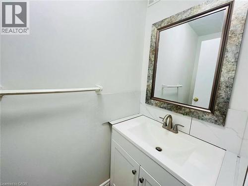 Bathroom vanity with integrated sink, brushed nickel faucet, and a decorative framed mirror - 212 Westcourt Place, Waterloo, ON - Indoor Photo Showing Bathroom