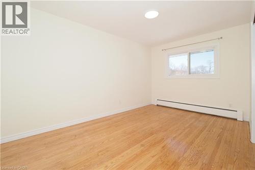 Room featuring hardwood floors, a window with natural light, and a baseboard heater - 24 Austin Drive, Waterloo, ON - Indoor Photo Showing Other Room