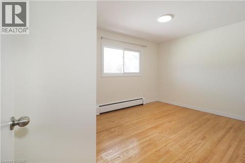 This room features hardwood flooring, a window providing natural light, and a ceiling-mounted light fixture - 24 Austin Drive, Waterloo, ON - Indoor Photo Showing Other Room