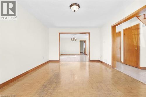 This interior space features hardwood flooring and an overhead light fixture - 18 Marcel Place, Hamilton, ON - Indoor Photo Showing Other Room