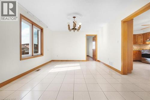 Spacious interior room featuring light-colored tiled flooring, light-colored walls, and wood trim - 18 Marcel Place, Hamilton, ON - Indoor Photo Showing Other Room