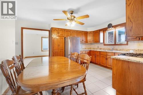 The kitchen features wood cabinetry, granite countertops, and tile flooring - 18 Marcel Place, Hamilton, ON - Indoor Photo Showing Other Room