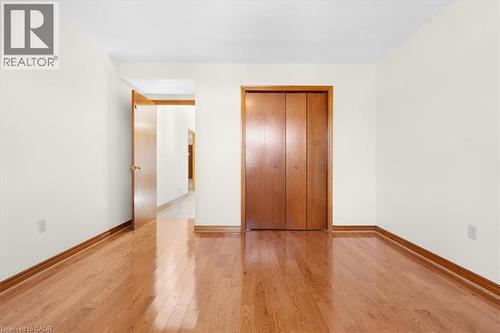 This room features polished hardwood flooring and light-colored walls - 18 Marcel Place, Hamilton, ON - Indoor Photo Showing Other Room