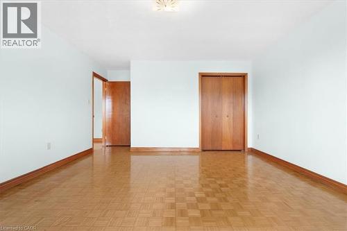 This room features light-colored walls, wood flooring, and wood trim throughout - 18 Marcel Place, Hamilton, ON - Indoor Photo Showing Other Room
