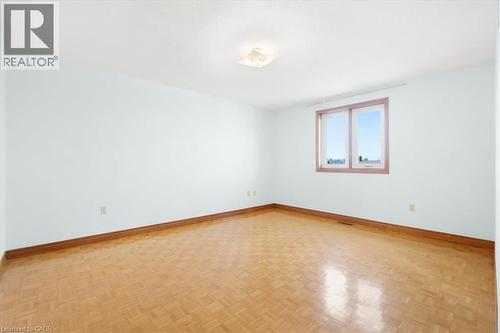 Room featuring light blue walls, wood parquet flooring, and a window providing natural light - 18 Marcel Place, Hamilton, ON - Indoor Photo Showing Other Room