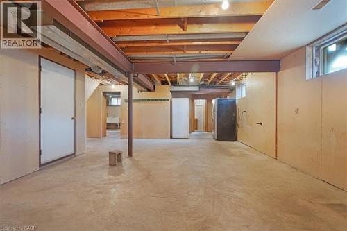 Spacious unfinished basement with exposed ceiling joists and support beams, featuring concrete flooring, a window, and a utility sink - 18 Marcel Place, Hamilton, ON - Indoor Photo Showing Basement