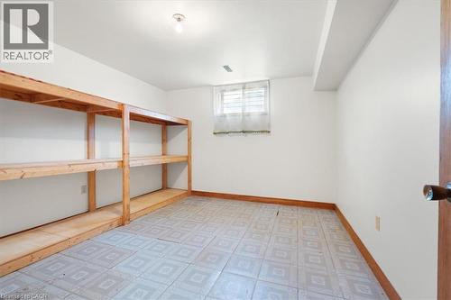The property offers a dedicated storage area with built-in wooden shelving units - 18 Marcel Place, Hamilton, ON - Indoor Photo Showing Other Room