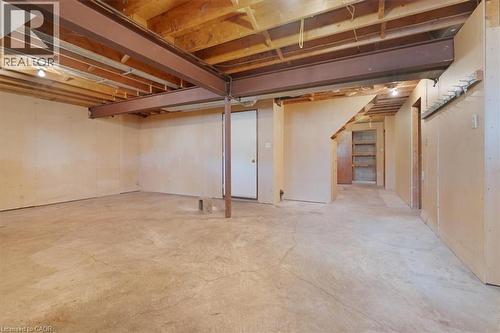 The property features an unfinished basement with exposed wooden joists, concrete flooring, and structural steel beams - 18 Marcel Place, Hamilton, ON - Indoor Photo Showing Basement