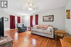 The living area features hardwood flooring, light-colored walls, and a ceiling fan - 