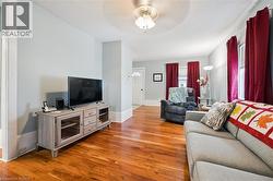 Living area with hardwood floors, light-colored walls, and a ceiling fan - 
