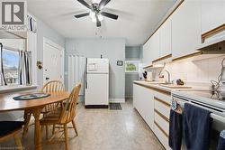 The property features a kitchen with white cabinetry, a ceiling fan, and a window providing natural light - 