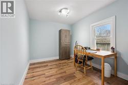 This room features light blue walls, laminate flooring, and a window providing natural light - 