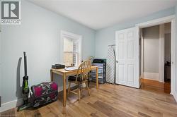 This room features light blue walls, a white framed window, and laminate floors - 