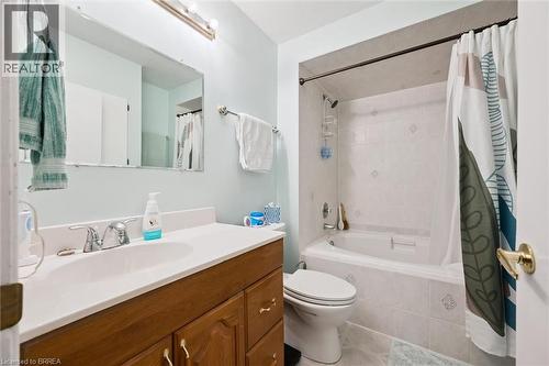 Bathroom featuring a vanity with a white countertop and wood cabinetry, a rectangular mirror, and a tiled shower-tub combination - 28 Davidson Street, Cambridge, ON - Indoor Photo Showing Bathroom