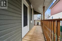 The property features a porch with a wooden floor and wooden railings, and gray siding - 