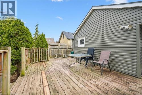 The property features an outdoor wooden deck with a railing, surrounded by mature trees - 28 Davidson Street, Cambridge, ON - Outdoor With Deck Patio Veranda With Exterior